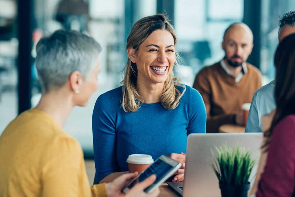 Woman with hearing loss laughing at work.