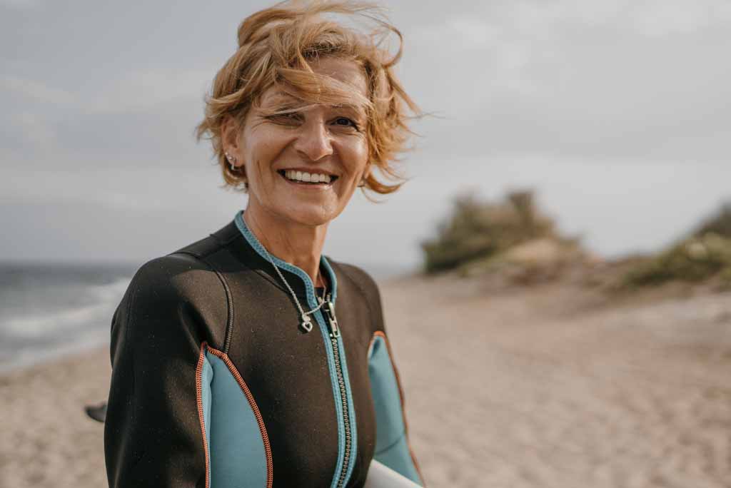 Woman surfer smiling after a great wave session.